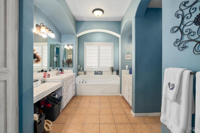 bathroom featuring tile patterned flooring, plenty of natural light, vanity, and a bathing tub