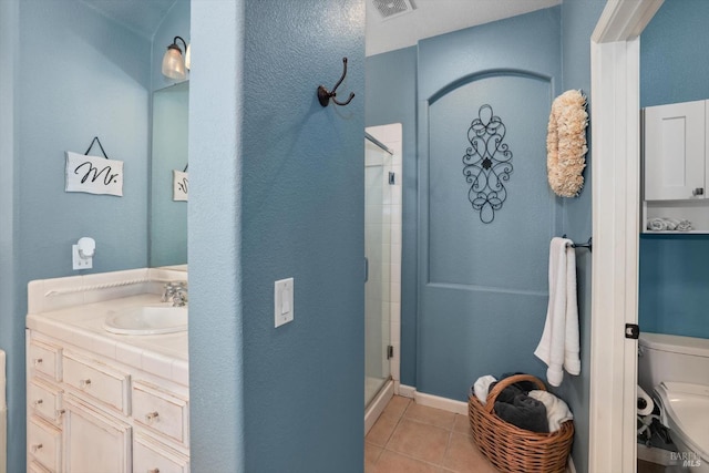 bathroom with tile patterned flooring, vanity, toilet, and a shower with shower door