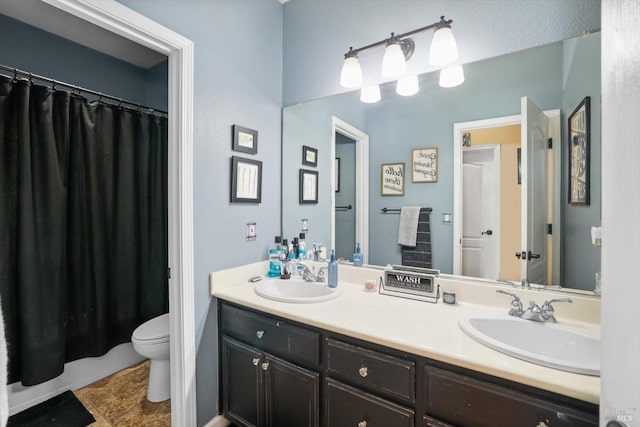 bathroom featuring curtained shower, vanity, and toilet