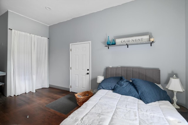 bedroom with dark hardwood / wood-style floors