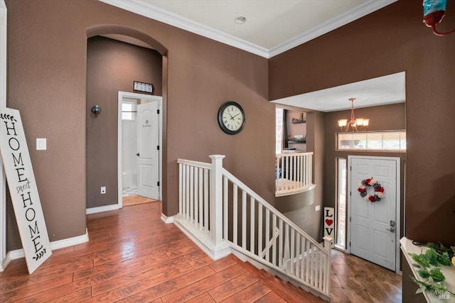 entryway featuring ornamental molding, a chandelier, and dark wood-type flooring