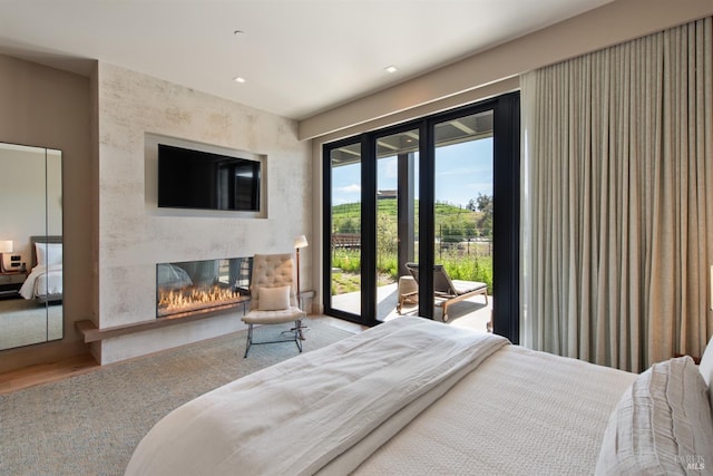 bedroom with access to outside, a fireplace, and recessed lighting