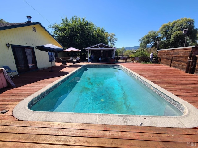 view of swimming pool with a gazebo and a deck