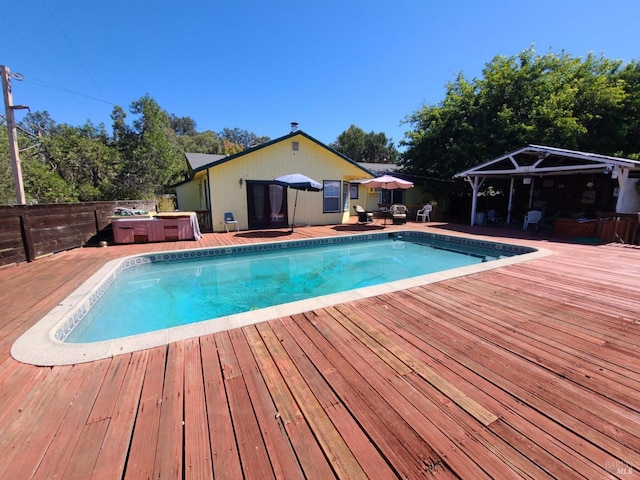 view of swimming pool featuring a jacuzzi and a wooden deck