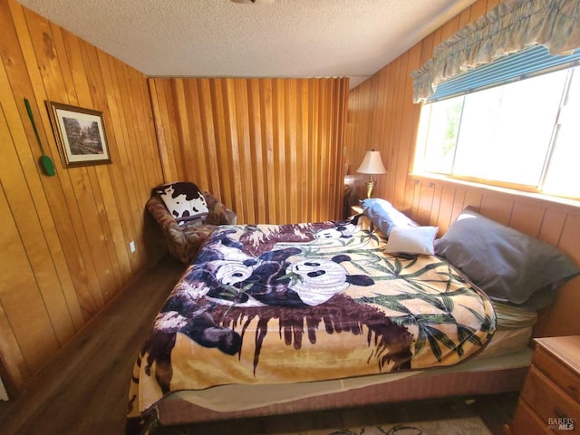 bedroom featuring wood walls and a textured ceiling