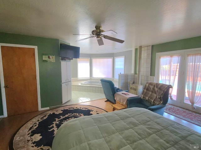 tiled bedroom featuring connected bathroom, ceiling fan, and a textured ceiling