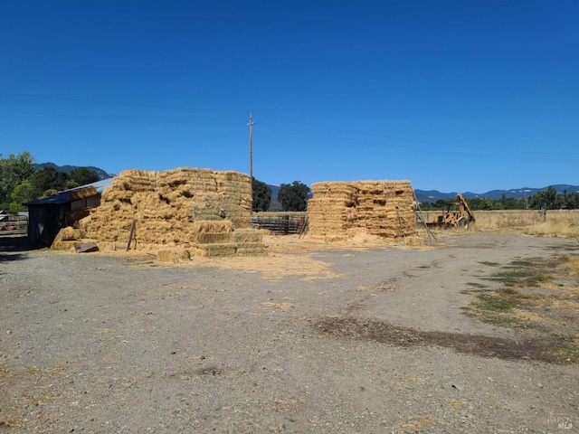 view of yard with a rural view and a mountain view