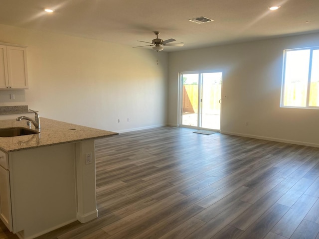 unfurnished living room with ceiling fan, dark hardwood / wood-style flooring, and sink