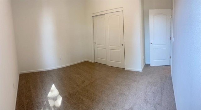 unfurnished bedroom featuring carpet floors and a closet