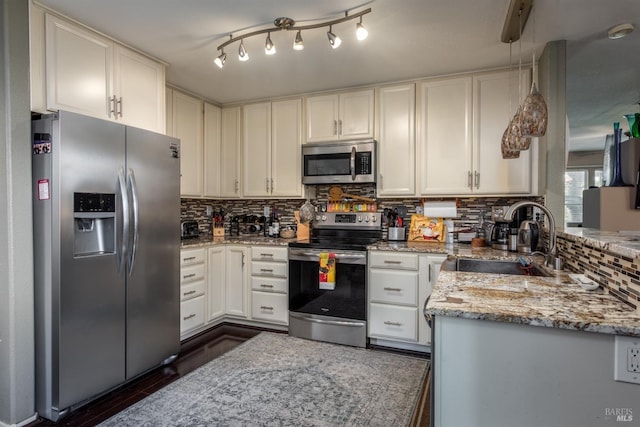 kitchen featuring white cabinetry, light stone countertops, sink, hanging light fixtures, and appliances with stainless steel finishes