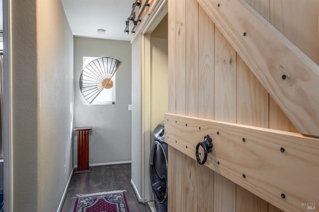 washroom with a barn door and dark hardwood / wood-style flooring