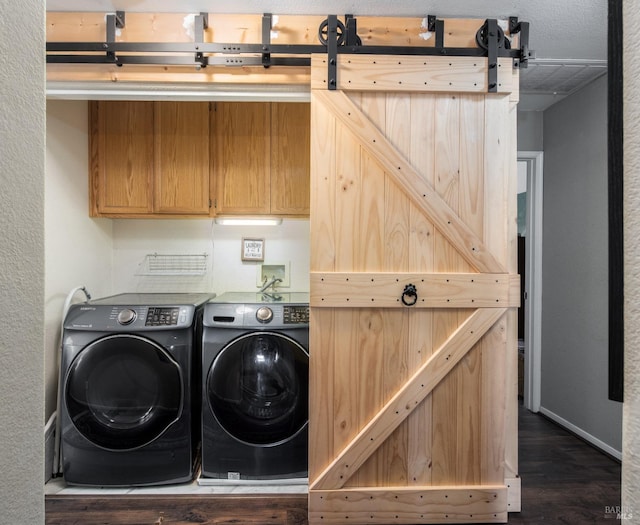 laundry area featuring dark hardwood / wood-style floors, a barn door, and independent washer and dryer