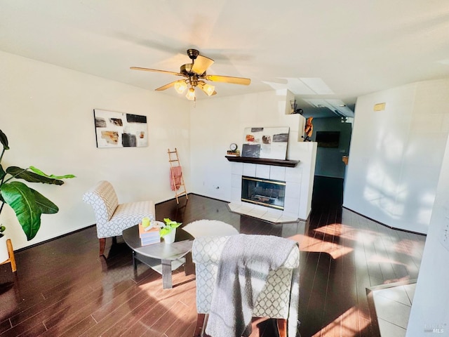 living room with a fireplace, wood-type flooring, and ceiling fan