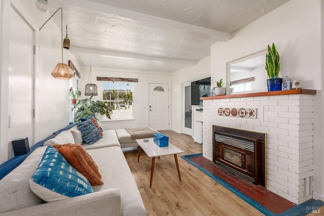 living room with beamed ceiling, hardwood / wood-style flooring, and a fireplace