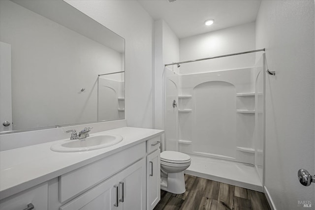 bathroom with walk in shower, vanity, toilet, and hardwood / wood-style floors