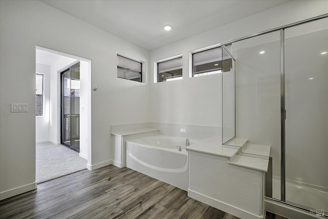 bathroom featuring hardwood / wood-style flooring and shower with separate bathtub