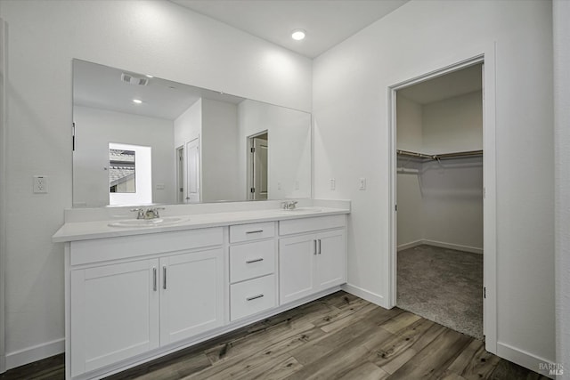 8953 Camino Colegio Rd, Rohnert Park, CA 94928 - bathroom featuring wood finished floors, double vanity, a spacious closet, baseboards, and recessed lighting