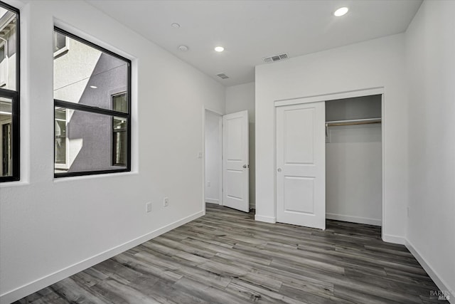 unfurnished bedroom featuring hardwood / wood-style flooring and a closet