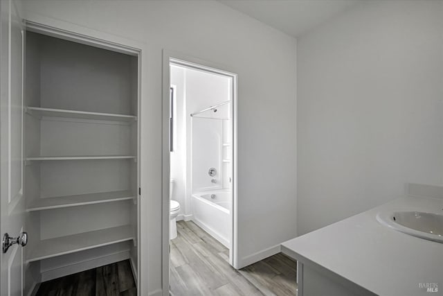 full bathroom with vanity, hardwood / wood-style flooring, shower / bathtub combination, and toilet