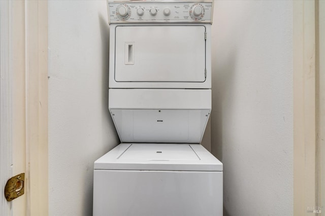 clothes washing area featuring stacked washer / dryer