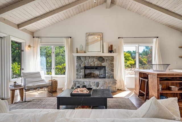 living room featuring lofted ceiling with beams, wood ceiling, hardwood / wood-style floors, and a fireplace