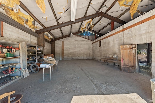 interior space with lofted ceiling and concrete flooring