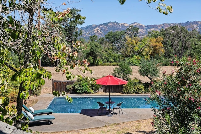 view of swimming pool featuring a mountain view and a patio area