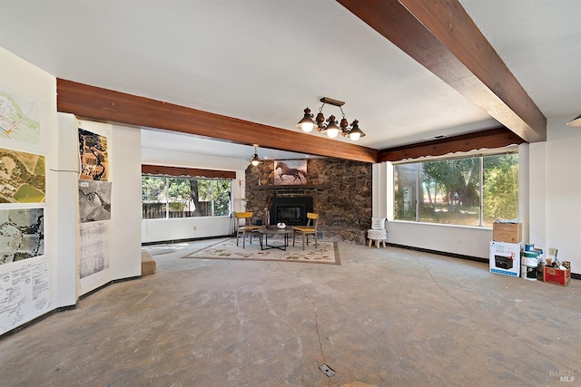 unfurnished living room with a stone fireplace, beam ceiling, and concrete floors