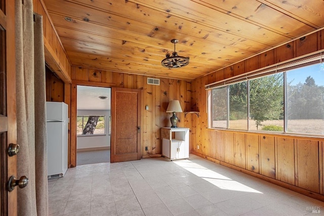 interior space featuring wooden ceiling and wood walls