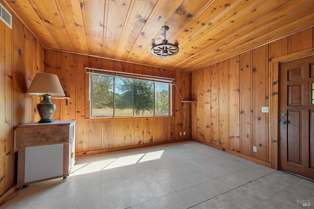 empty room featuring wooden ceiling and wooden walls