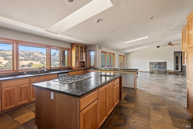 kitchen featuring ceiling fan, a mountain view, a kitchen island with sink, and sink