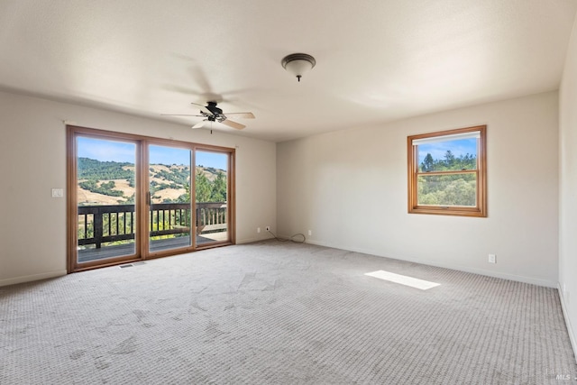 unfurnished room with ceiling fan and carpet