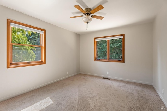 unfurnished room with light carpet, ceiling fan, and plenty of natural light