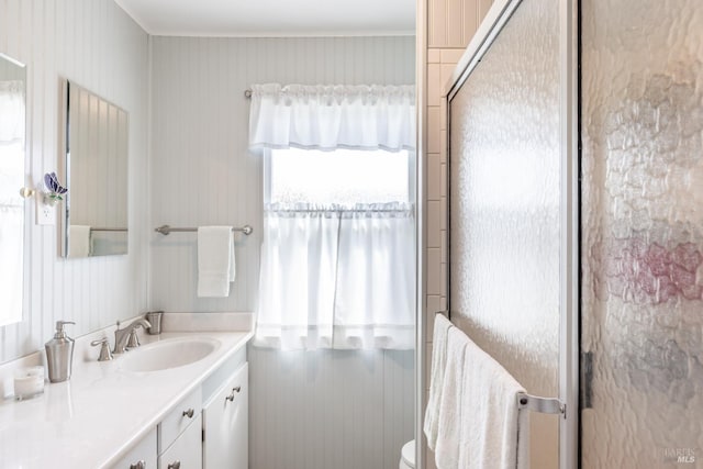 bathroom with a shower with shower door, vanity, and toilet