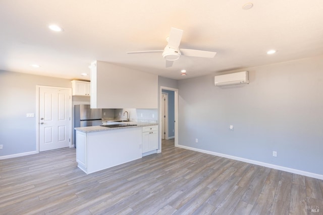 kitchen with stainless steel fridge, sink, ceiling fan, and white cabinets