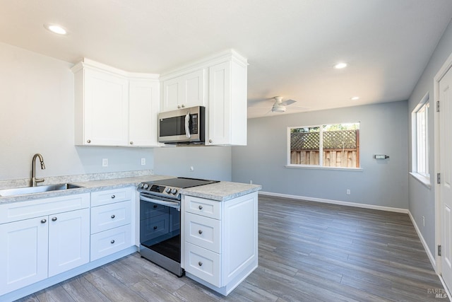 kitchen featuring appliances with stainless steel finishes, light hardwood / wood-style floors, sink, and white cabinets