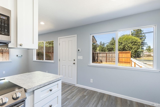 kitchen with stainless steel appliances, white cabinetry, and a healthy amount of sunlight