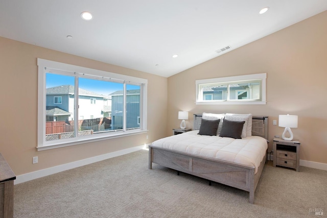 carpeted bedroom featuring lofted ceiling and multiple windows