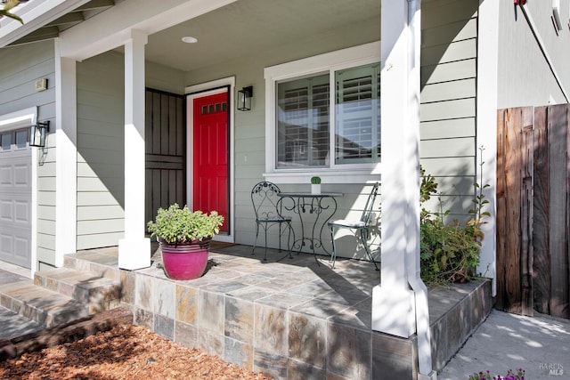 doorway to property with a porch and a garage