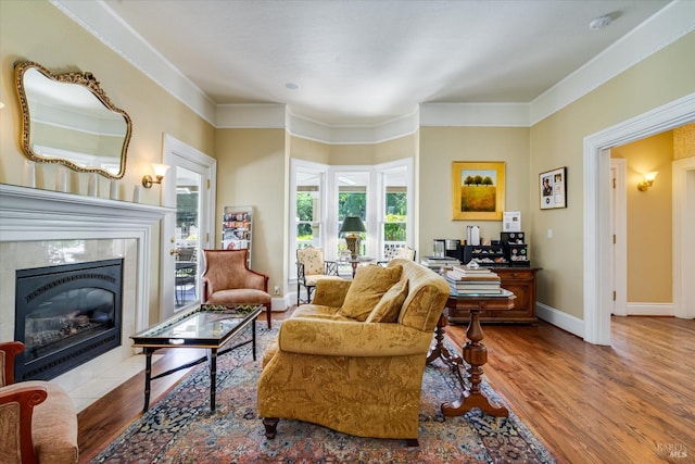 living room featuring crown molding, light hardwood / wood-style floors, and a tile fireplace