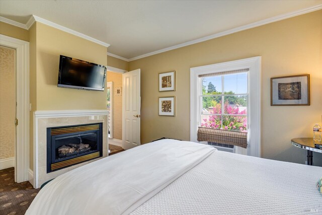 bedroom with a premium fireplace and crown molding