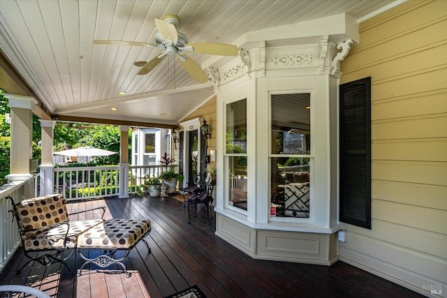 wooden deck featuring a porch and ceiling fan