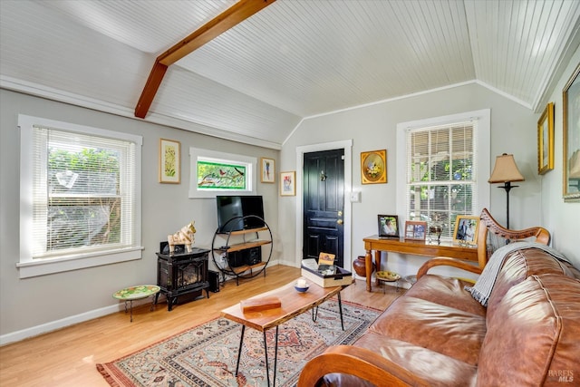 living room featuring lofted ceiling with beams, a wood stove, and hardwood / wood-style flooring