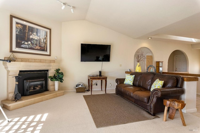 living room featuring lofted ceiling, light colored carpet, and track lighting