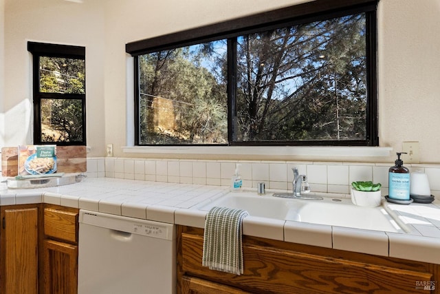 kitchen featuring dishwasher, tile counters, and backsplash