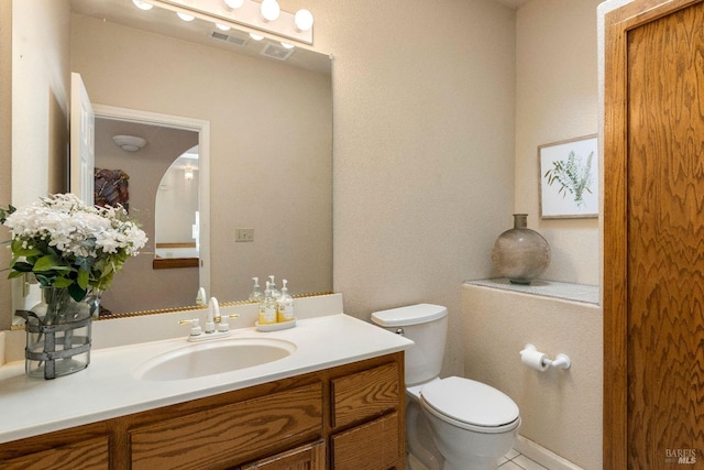 bathroom with vanity, toilet, and tile patterned floors