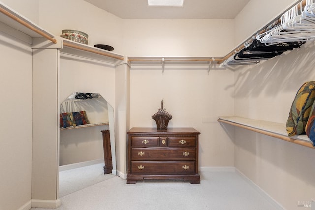 walk in closet featuring light colored carpet