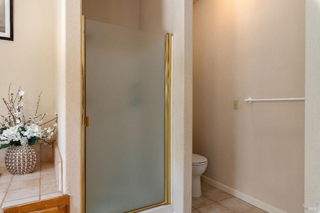 bathroom with tile patterned floors, a shower with shower door, and toilet