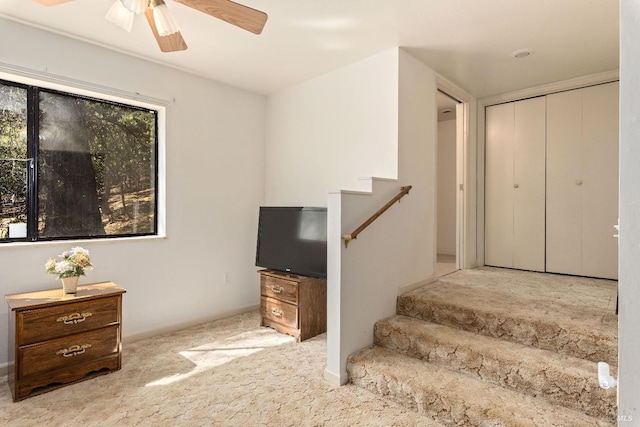 interior space with carpet and ceiling fan