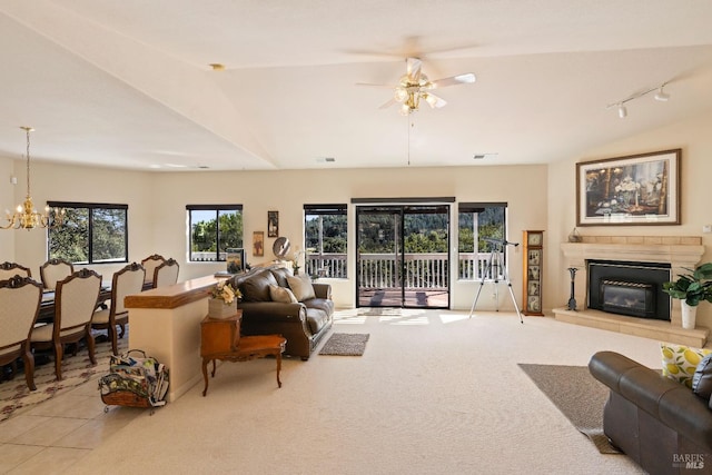 carpeted living room featuring ceiling fan with notable chandelier, lofted ceiling, and rail lighting